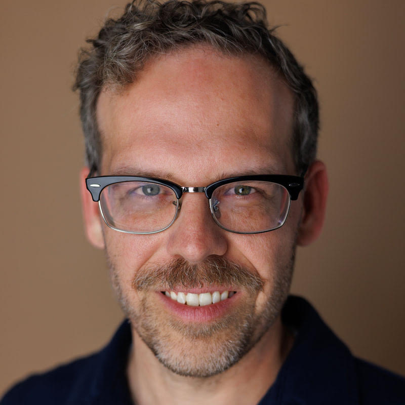 Headshot of Joshua Brown, middle aged white man with glasses, smiling